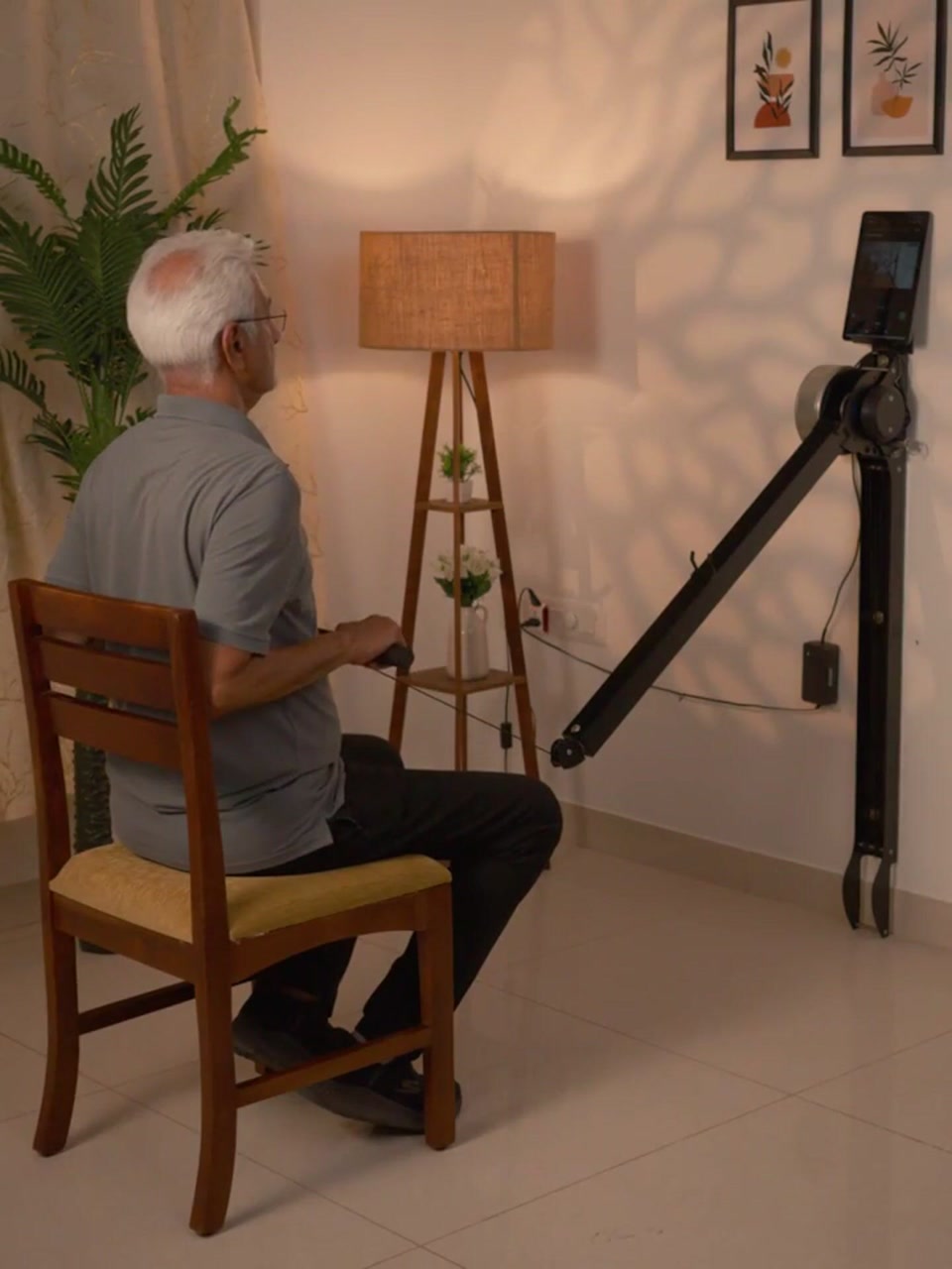 An older Ferra member doing a seated row on the wall-mounted Ferra machine at home